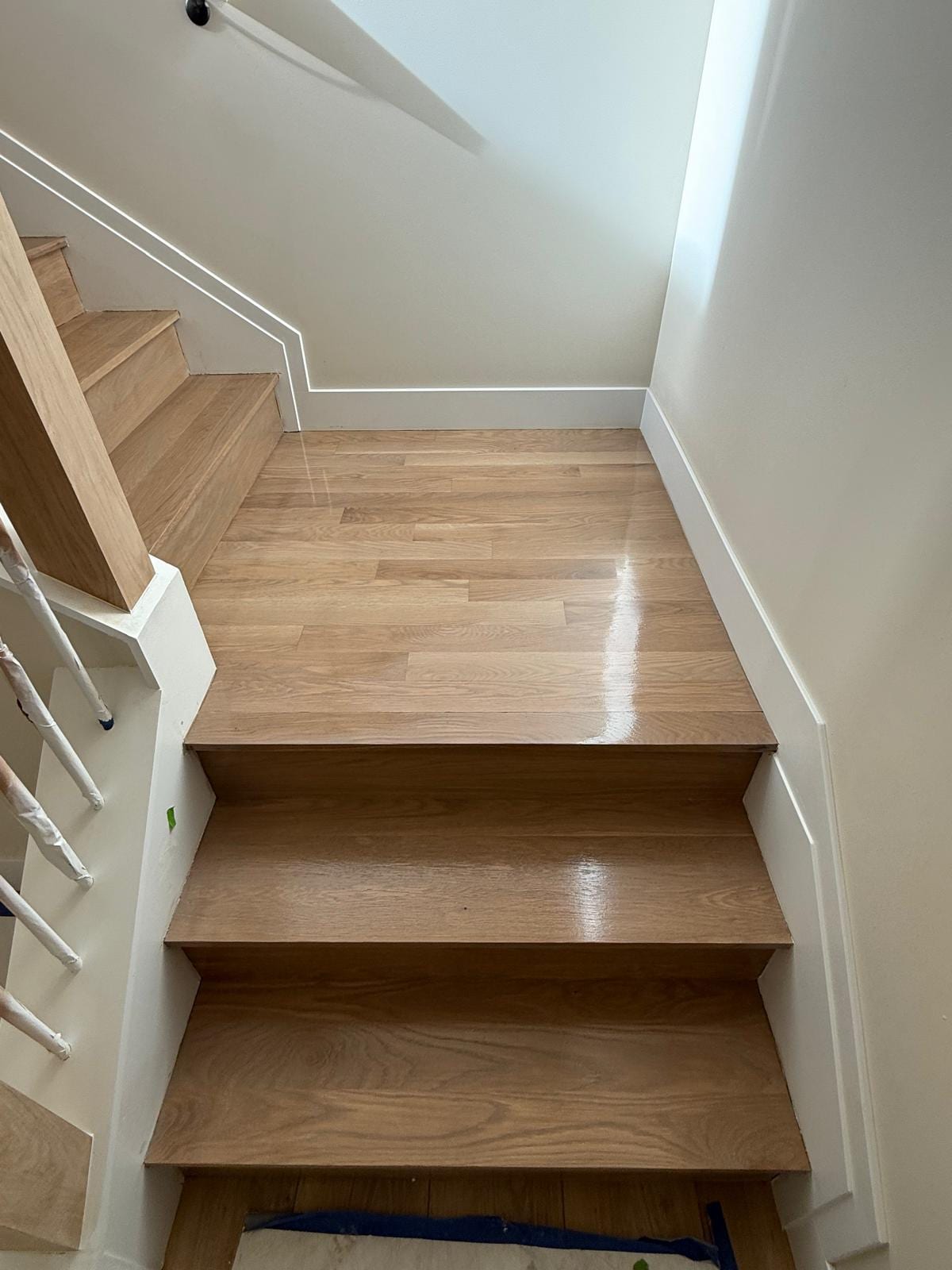 Entryway and staircase with new hardwood flooring in a light tone