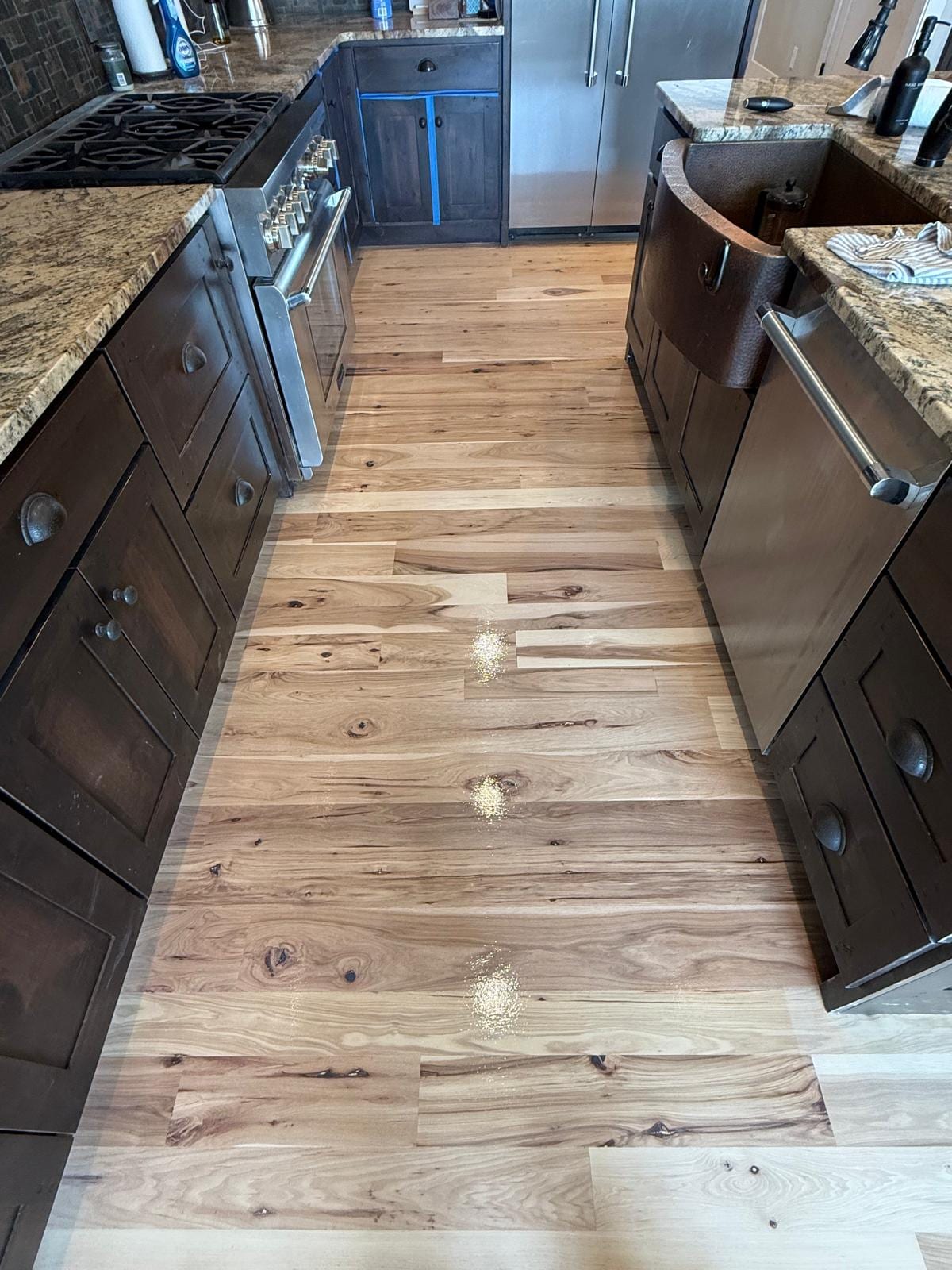 Modern kitchen with refinished hardwood flooring in a warm medium tone
