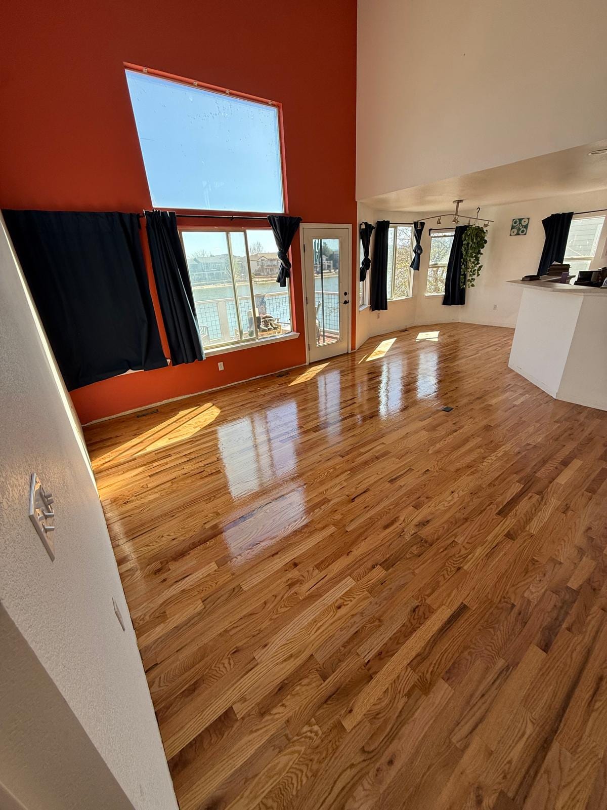 Large open studio or workspace with refinished hardwood flooring in a warm medium tone